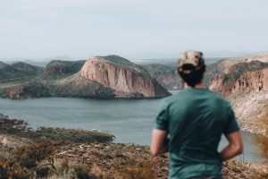 a man standing on top of a lush green hillside